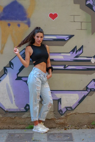 Moda bela de cabelos compridos modelo jovem posando no graffiti de volta — Fotografia de Stock