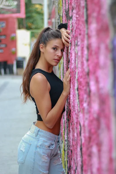 Trendy mooie langharige jonge model poseren op graffiti terug — Stockfoto