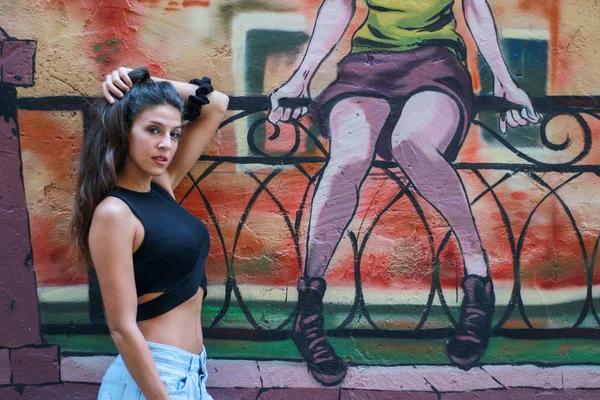 Moda hermosa modelo joven de pelo largo posando en el graffiti espalda —  Fotos de Stock