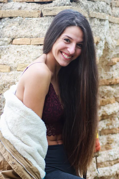 Hermosa joven sonriente mujer en chaqueta de cuero negro en ruinas o — Foto de Stock