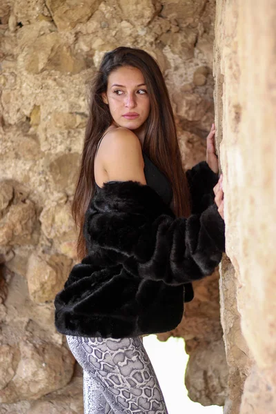 Hermosa joven en chaqueta de cuero negro en ruinas del castillo — Foto de Stock
