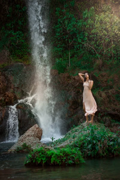 Sexy Frau posiert auf dem Felsen zwischen grünen tropischen Pflanzen und werden — Stockfoto