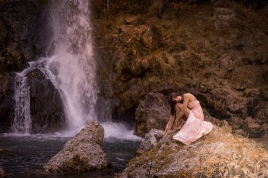 Çekici kız peri hızlı ormanda arasında kaya üzerinde poz