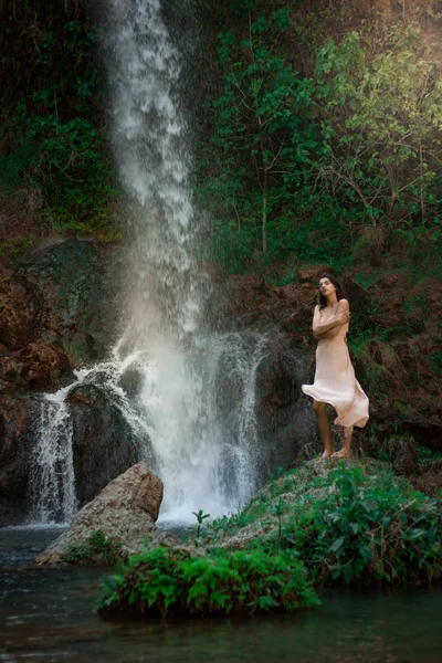 Sexy Frau posiert auf dem Felsen zwischen grünen tropischen Pflanzen und werden — Stockfoto