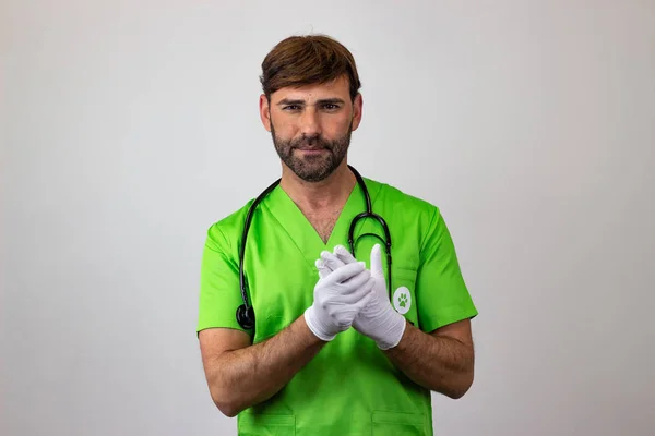 Porträt eines männlichen Tierarztes in grüner Uniform mit braunem h lizenzfreie Stockbilder