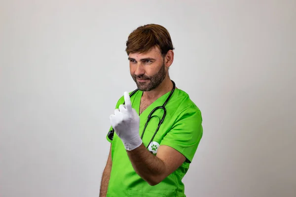 Portrait of male veterinary doctor in green uniform with brown h