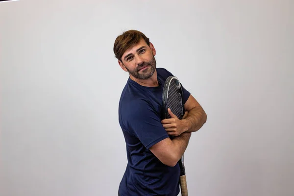 Retrato de joven guapo jugando tenis sosteniendo una raqueta w —  Fotos de Stock