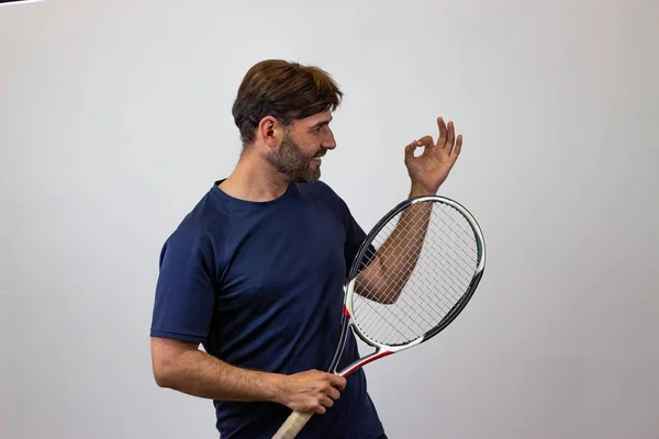 Porträtt av stilig ung man spela tennis hålla ett racket w — Stockfoto