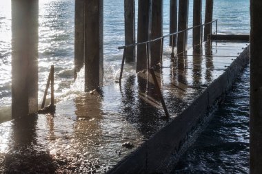 Beton dalgakıran deniz kıyısında güneşli günde bir fırtına sırasında beton sütunlarla