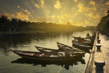 Ahşap tekneler Hoi An Antik şehir, Vietnam için tarih Prş Bon nehrinde. Nehirde yansıyan sahildeki sarı eski evleri. Vietnam
