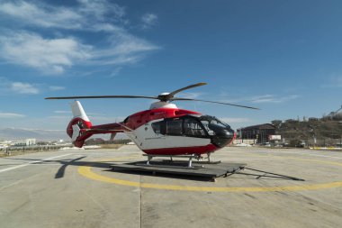 Red ambulance helicopter on the helipad clipart