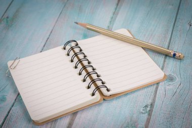 Açık defter ile boş sayfaları ve kalem mavi ahşap masa üzerinde görüntüsünü üstten görünüm