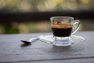 Siyah kahve ahşap bir masa yerleştirilen bir açık cam yerleştirilir.