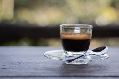 Siyah kahve ahşap bir masa yerleştirilen bir açık cam yerleştirilir.