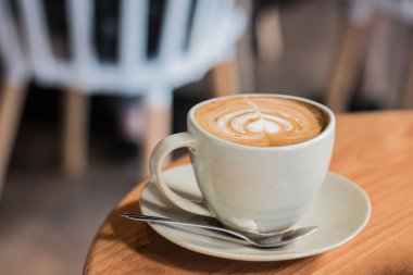 Kahve latte kalp şeklinde yığılmış üzerinde ahşap zemin, fincan kahve güzel Latte ile sanat.