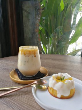 Karamel kahve ve portakal yoğurt kek ahşap masa üzerine buzlu