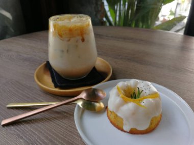 Karamel kahve ve portakal yoğurt kek ahşap masa üzerine buzlu