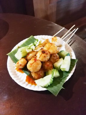 muz yaprak salatalık ile dekore edilmiş üstüne domuz topu sopa 