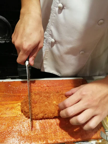 Japanese chef is cutting pork tonkatsu on wood cutting board