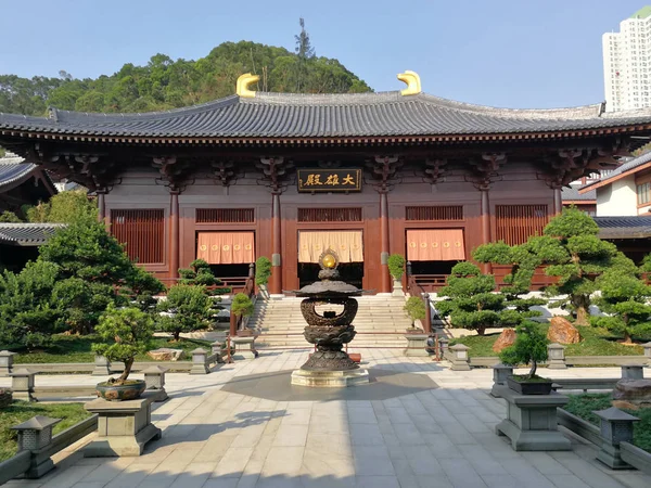 优雅的木制遗产寺庙与对比现代建筑的背景 — 图库照片