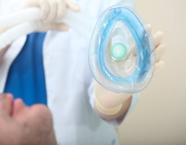 Erkek hasta solunum anestezi maskesi kadın doktor elinde nefes ile önce.