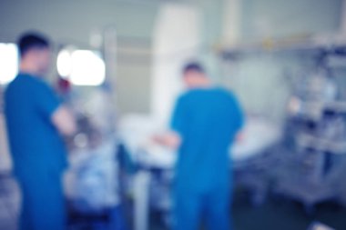 Bulanık sihouettes erkek doktorların yoğun bakım ünitesinde odaklanmamış arka plan kritik hasta danışmanlık.