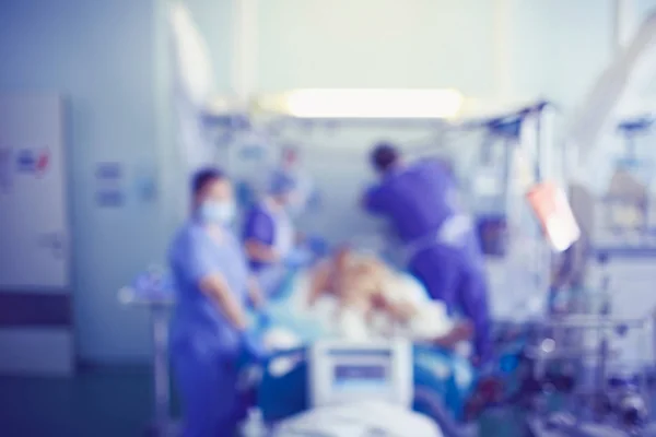 Equipe médica à beira do leito do paciente na UTI, fundo desfocado . — Fotografia de Stock