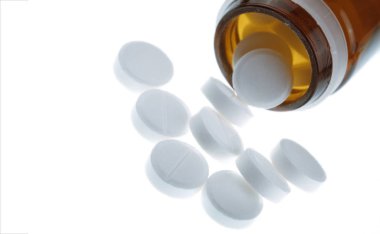 Beyaz bir arka plan üzerinde izole edilmiş bir şişeden dağılmış haplar