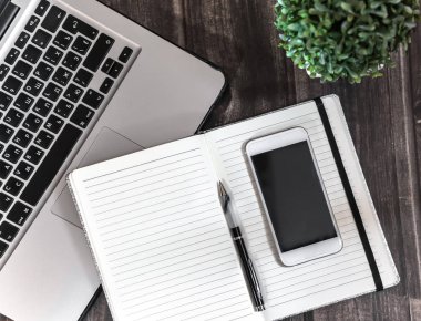 çalışma alanı, laptope, defter, telefon ve ahşap masa, yeşil bitki, Not defteri satırlarında kalem