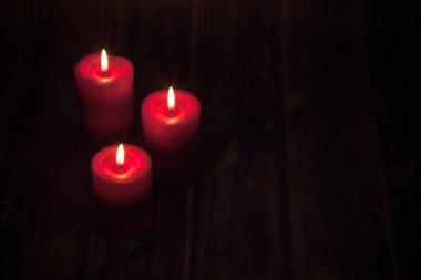 Üç yanan kırmızı mum koyu siyah arka plan, üç alevler, Noel ve yılbaşı süslemeleri