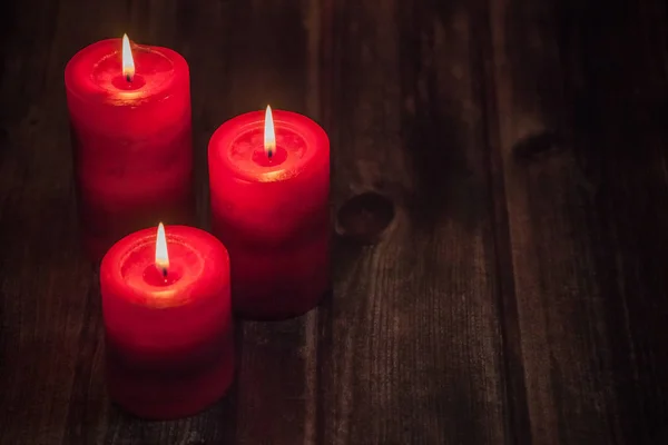Τρία Κόκκινα Κεριά Φώτα Στο Τραπεζι Ξυλινο Ρουστίκ — Φωτογραφία Αρχείου