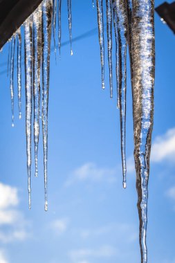 Icicle'ı çatıdan buz saçak, şeffaf bir parçası damlayan temizlemek şeffaf bir icicl mavi ebo