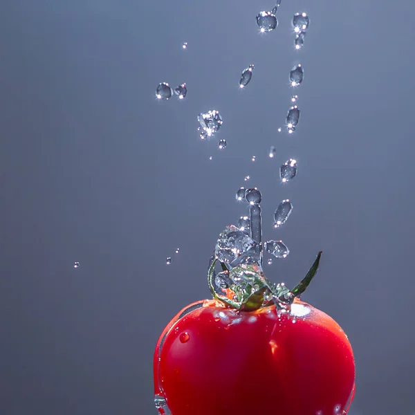 Tomate Rouge Vif Avec Éclaboussure Transparente Eau Sur Fond Gris — Photo