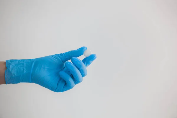 Mão Feminina Azul Luva Médica Esticando Pílula Redonda Branca Fundo — Fotografia de Stock