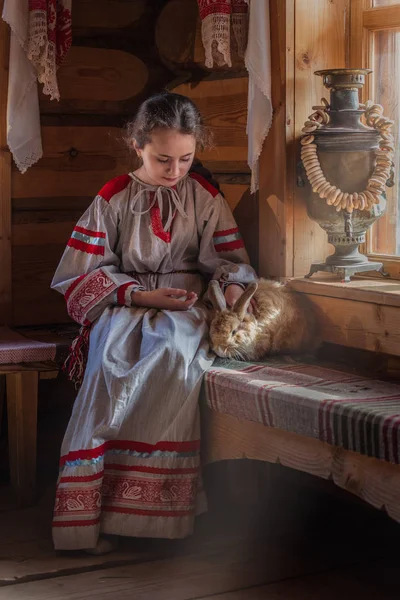 girl in Russian traditional dress, Russian national setting, bunny in hand, pushy pet, retro style