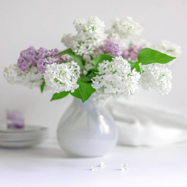 bir festival masada beyaz bir vazo içinde bir buket lila güzel dalları, beyaz ve mor çiçekler, masa dekorasyonu, düğün masası