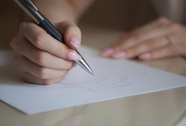 kız bir diyagram çizer ve bir kağıt parçası, iş ve iş tasarımı, çalışma, yönetim üzerine yazıyor