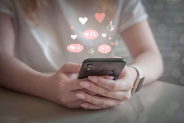 Sosyal medya, akıllı telefon ile sosyal ağ konsepti, cep telefonu kullanan genç kadın, kadın elleri ile telefon tutan medya ağı bildirim simgeleri, sanal yaşam, kalpler ve beğeniler