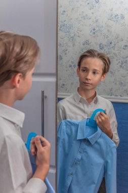 bir çocuk beyaz gömlek duruyor ve mavi gömlek, zor bir seçim, geri okula, eğitim, kolej, lise, gymnasium, lise, yüksek seviye, notlar ve puanları çalışır