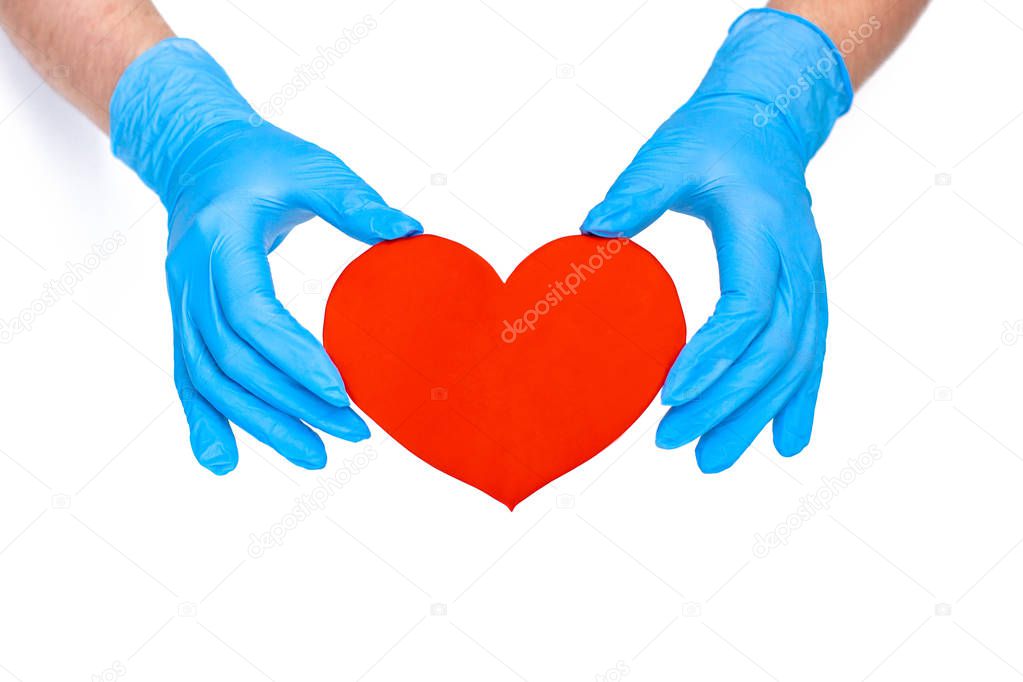 hands in blue gloves holding a red paper heart on a white background, concept of health, medicine, heart disease