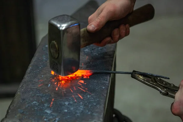 forge, traditional manual metal processing, hammer hits the hot workpiece on the anvil