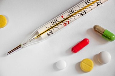 geleneksel bir cam cıva termometre etrafında ilaç ile 38 derece, tablet ve kapsül bir sıcaklık gösterir