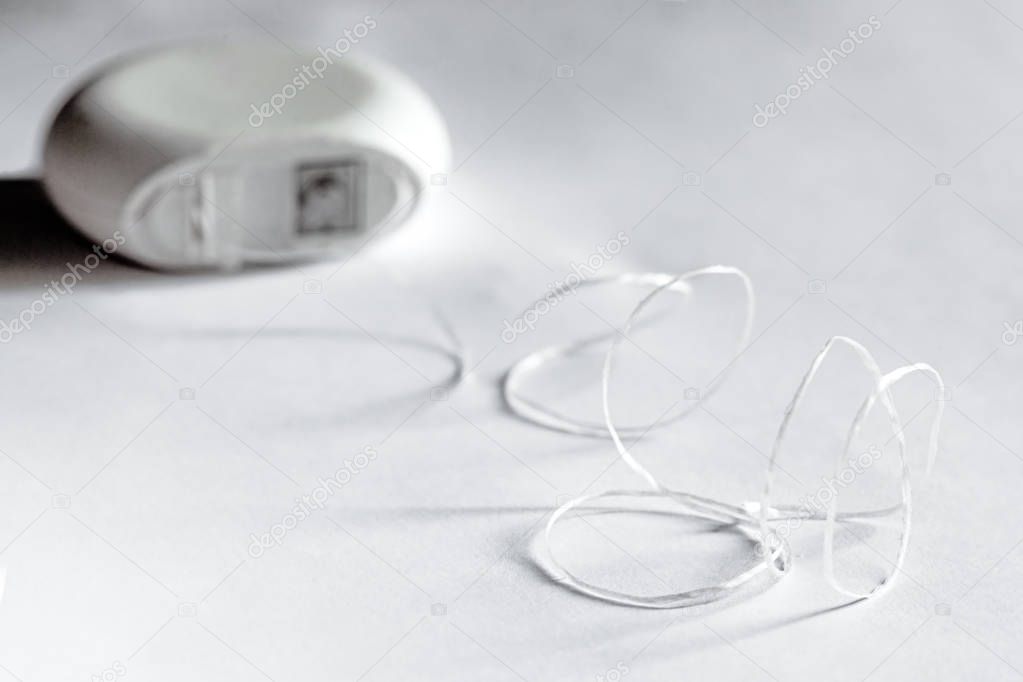 Dental floss. Tool for teeth hygiene. Concept of dental care. Black and white photo