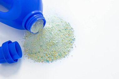 Bulaşık makinesi dokusu için toz, yakın plan, beyaz arka planda izole edilmiş, yıkanmak için mavi plastik kap, beyaz üzerine dağılmış toz.