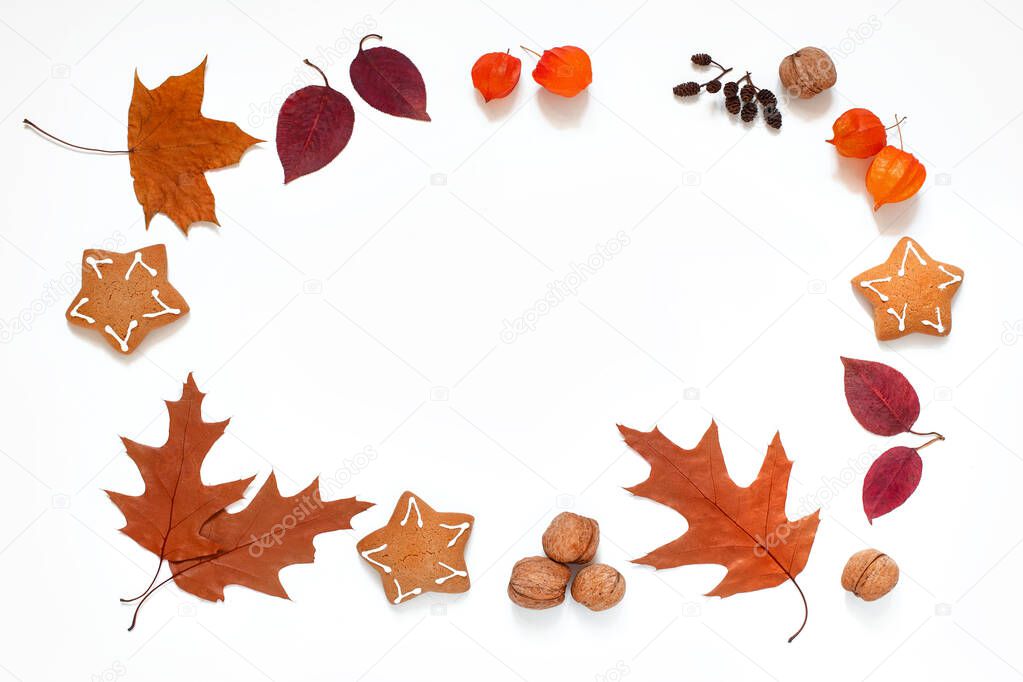 autumn frame of fallen leaves, cookies, physalis and nuts on a white background, free space in the center, autumn layout,