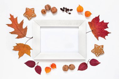 Sonbahar düzeni, ahşap beyaz çerçeve, düşen sonbahar parlak yaprakları, böğürtlenler, beyaz arka planda meyveler, boş, taban, tasarım için makara, samimi sonbahar havası.