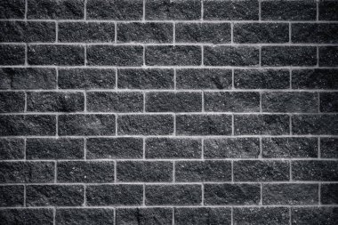 Siyah tuğla duvar, yontulmuş taş bloklar.