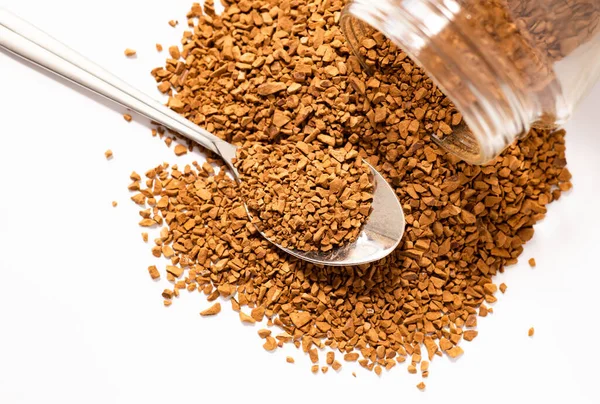 Hazır kahve konservesinden serpilmiş, bir kaşık granüle kahve yakın plan, beyaz arka planda izole edilmiş, kahve molası...