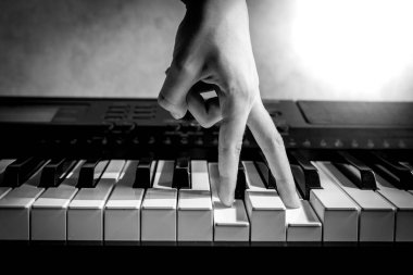 Müzisyen parmakları piyano tuşlarında, blues ve jazz 'da, siyah beyaz bir müzik aleti çalmayı öğreniyor.