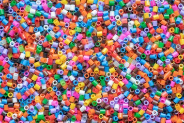 çok renkli plastik boncuklar, küçük plastik mozaik parçaları, çocukların yaratıcılığı için arka plan, ince motor becerilerin gelişimi
